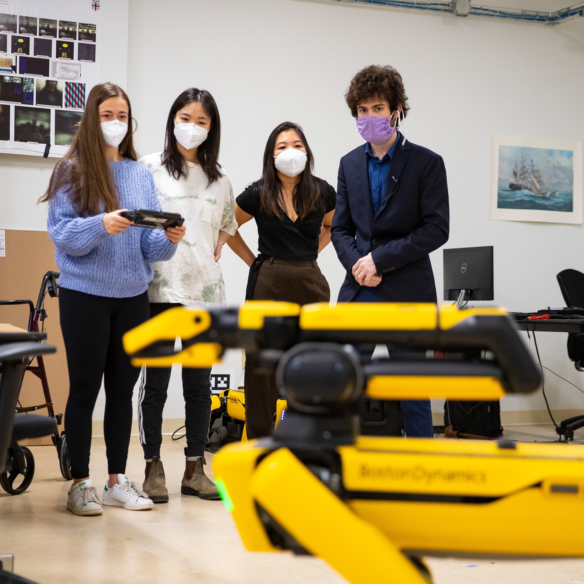 4 students operate Spot in a classroom setting